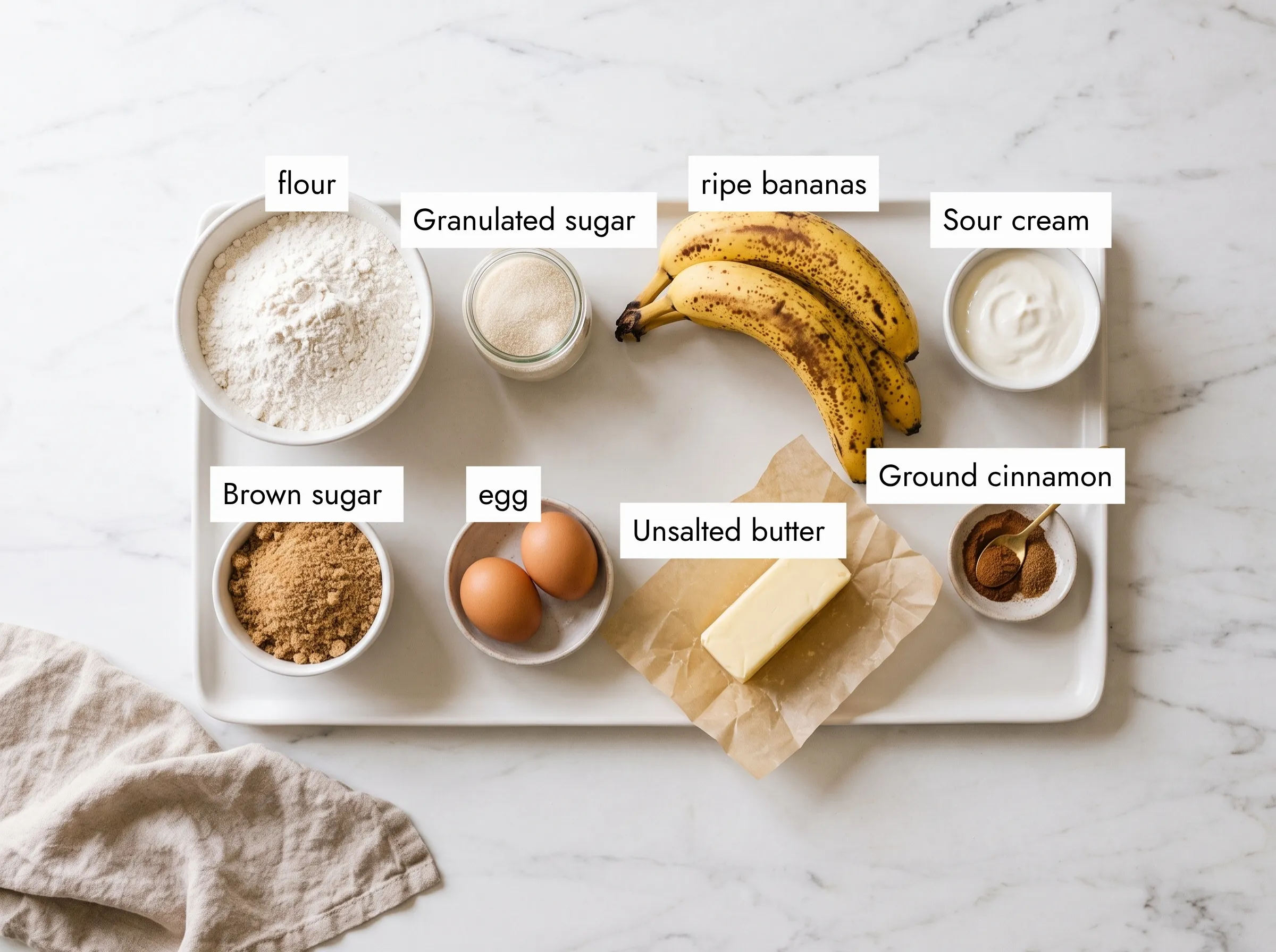 Raw ingredients for banana coffee cake recipe laid out on marble counter
